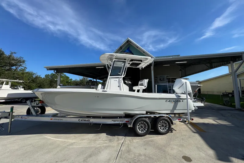 The Image of 2026 Caymas 24 HB boat on trailer, parked outdoors under clear blue sky. - 1