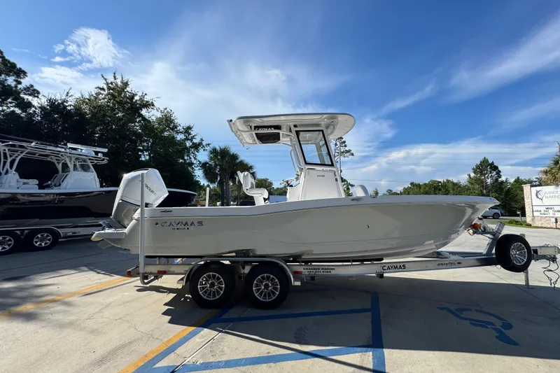 Slide: The Image of 2026 Caymas 24 HB boat on trailer under clear blue sky. - 10