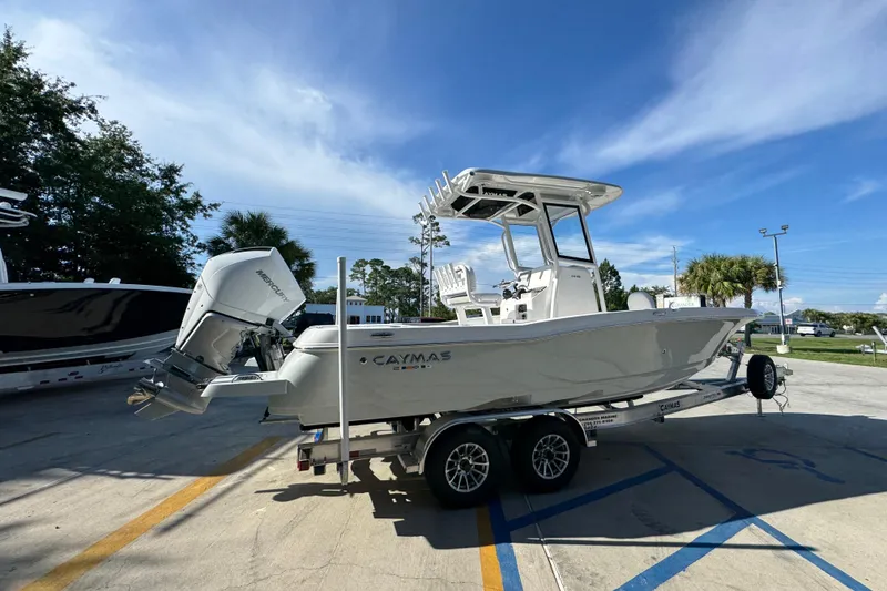 Slide: The Image of 2026 Caymas 24 HB boat on trailer, parked outdoors under clear blue sky. - 11