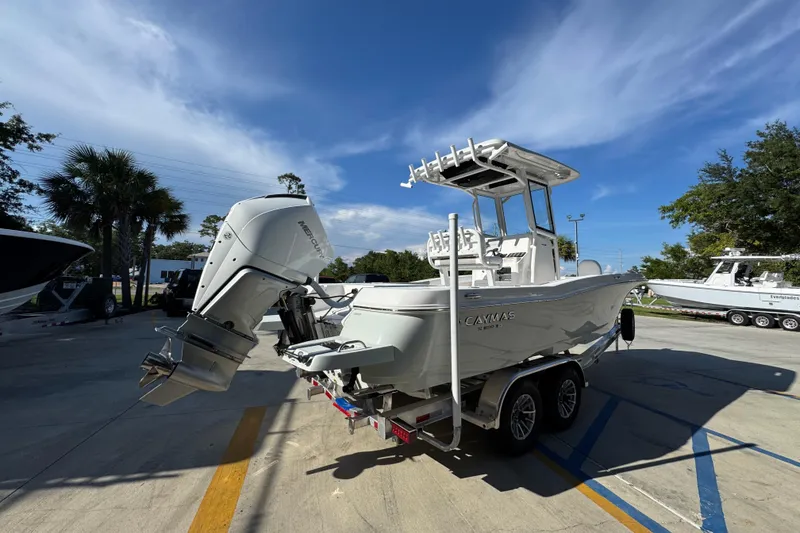 Slide: The Image of 2026 Caymas 24 HB boat with Mercury outboard engine on trailer, parked outdoors. - 12