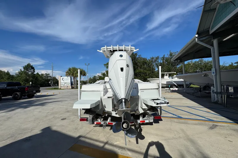 Slide: The Image of 2026 Caymas 24 HB boat on trailer, parked outdoors under clear blue sky. - 14