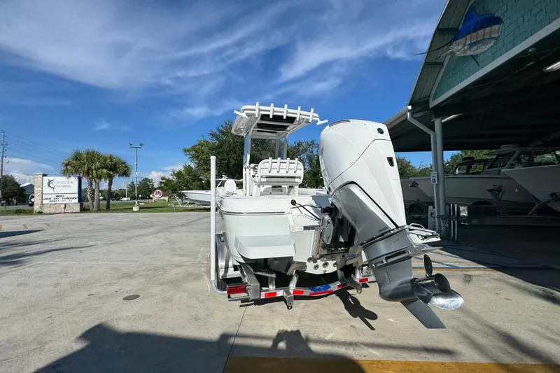 Slide: The Image of 2026 Caymas 24 HB boat with powerful outboard motor in a sunny marina setting. - 15