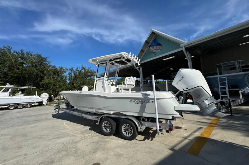 Slide: The Image of 2026 Caymas 24 HB boat on trailer, parked outdoors under clear blue sky. - 17