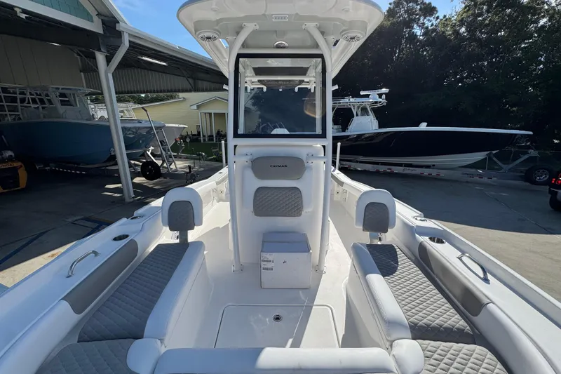 Slide: The Image of 2026 Caymas 24 HB boat interior with seating and console, docked in a marina. - 23
