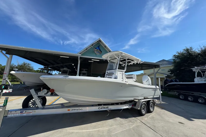 Slide: The Image of 2026 Caymas 24 HB boat on trailer under clear blue sky. - 3