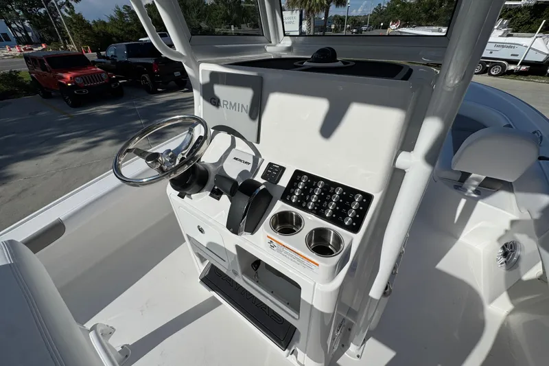 Slide: The Image of 2026 Caymas 24 HB boat console with Garmin navigation, steering wheel, and control panel. - 32
