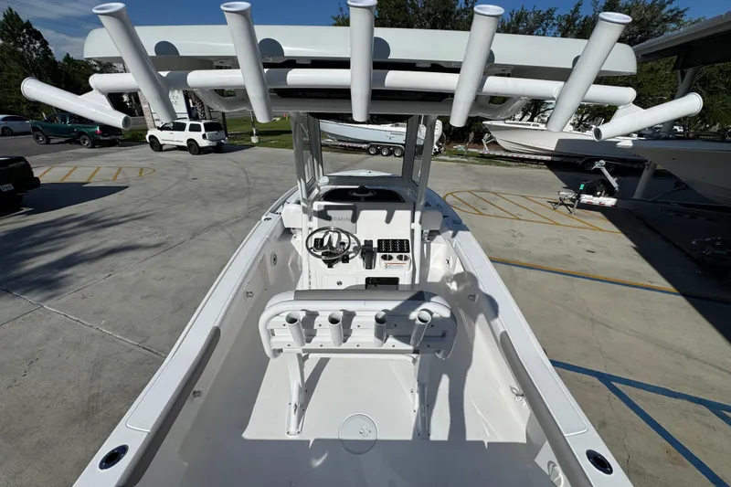 Slide: The Image of 2026 Caymas 24 HB boat interior with rod holders and steering console in a parking lot. - 34