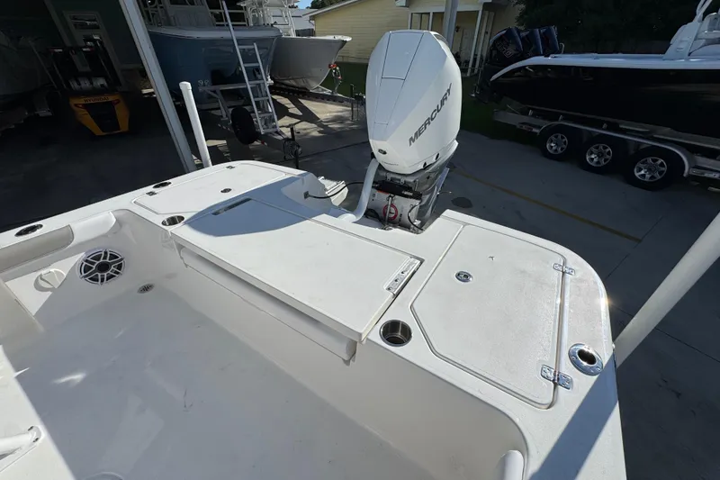 Slide: The Image of 2026 Caymas 24 HB boat with Mercury outboard engine, docked in a marina. - 35