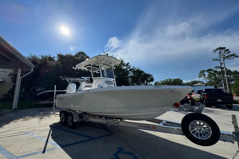 Slide: The Image of 2026 Caymas 24 HB boat on trailer under clear blue sky. - 8