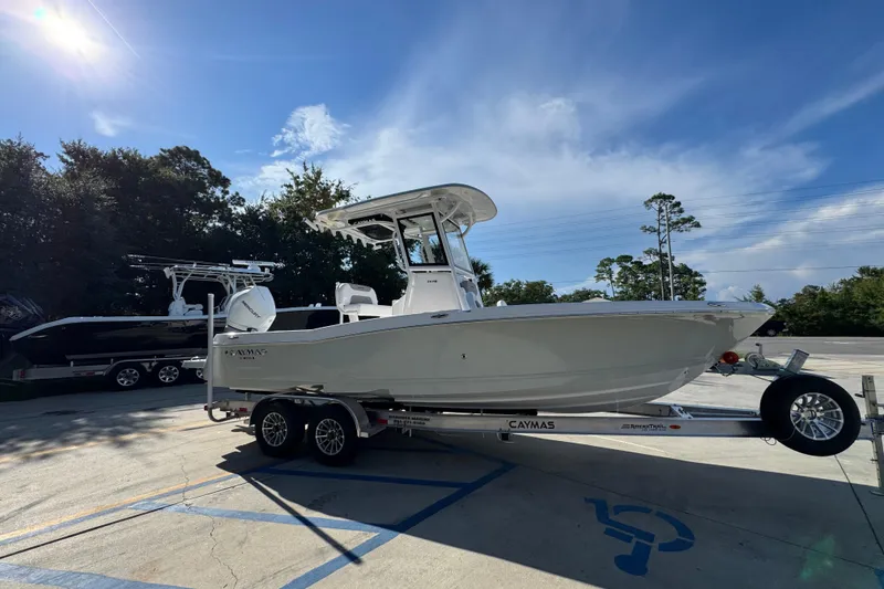 Slide: The Image of 2026 Caymas 24 HB boat on trailer in sunny outdoor setting. - 9