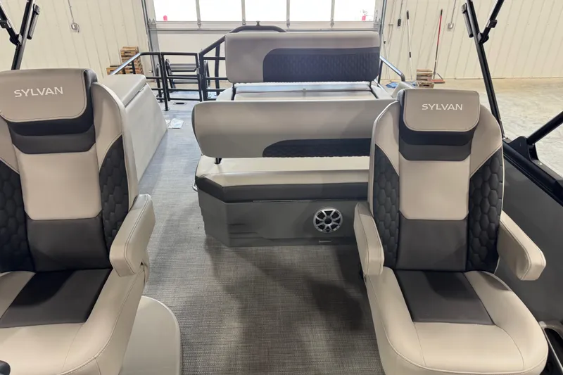 Slide: The Image of 2026 Sylvan L-5 boat interior with gray and black seating in a showroom. - 10