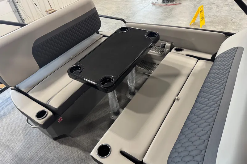 Slide: The Image of Interior seating of 2026 Sylvan L-5 boat with table and cup holders. - 13