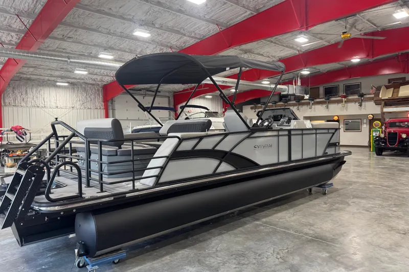 Slide: The Image of 2026 Sylvan L-5 pontoon boat in a spacious indoor showroom. - 4