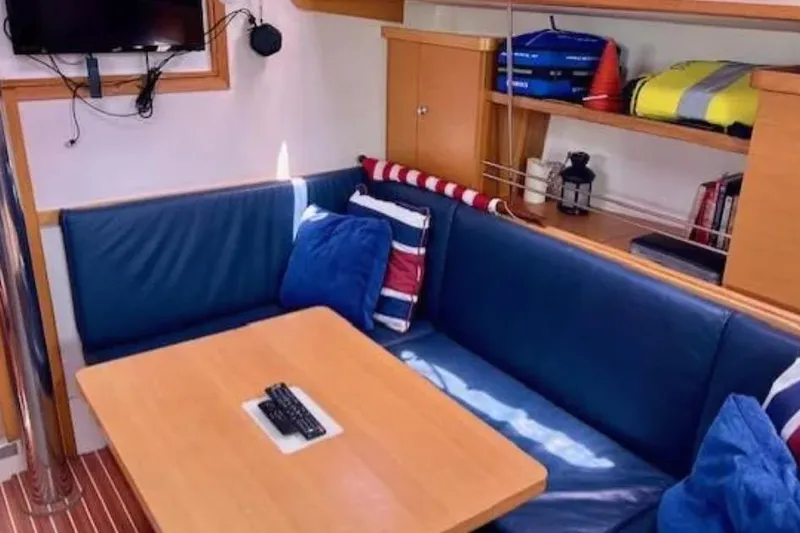 Slide: The Image of Cozy interior of 2007 Hanse 400 yacht with blue seating and wooden table. - 12