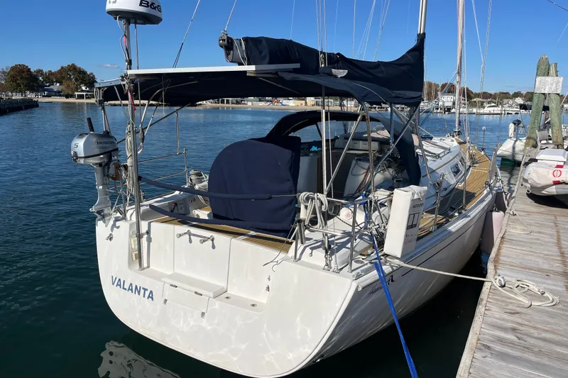 Slide: The Image of 2007 Hanse 400 sailboat docked at marina, featuring a covered cockpit and outboard motor. - 28