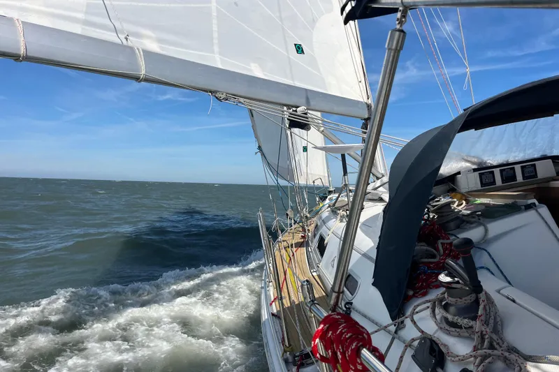 Slide: The Image of Sailing Hanse 400 yacht from 2007 navigating through ocean waves under clear blue skies. - 31