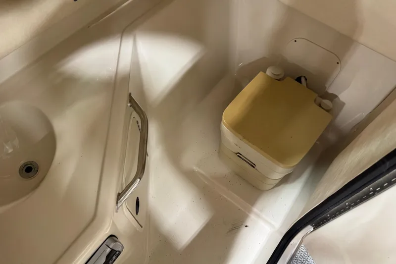 Slide: The Image of 2004 Sea Ray 270 Sundeck interior with portable toilet and sink. - 10