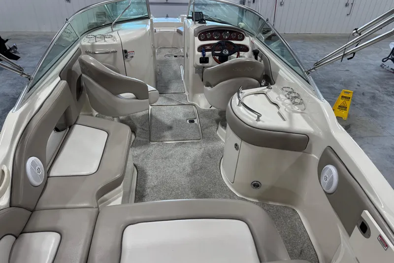 Slide: The Image of 2004 Sea Ray 270 Sundeck interior with seating, steering console, and cup holders. - 14
