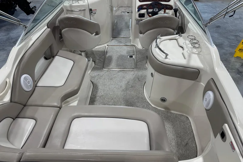 Slide: The Image of 2004 Sea Ray 270 Sundeck interior with seating, steering wheel, and carpeted flooring. - 7