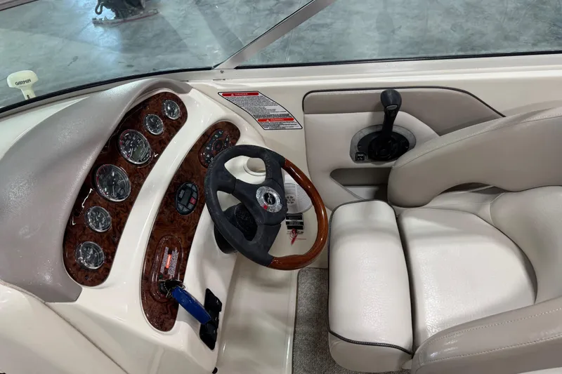 Slide: The Image of 2004 Sea Ray 270 Sundeck dashboard with gauges, steering wheel, and throttle controls. - 9