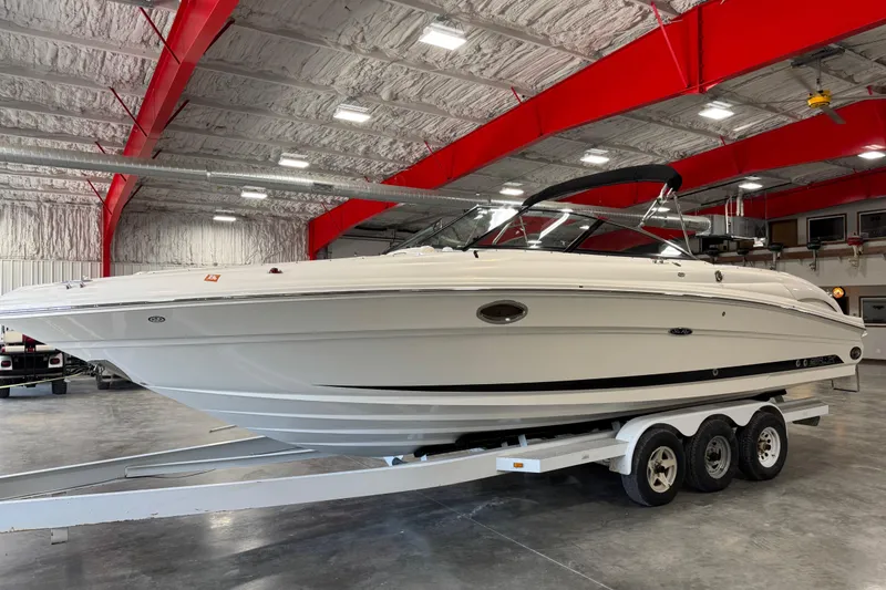 The Image of 2005 Sea Ray 290 SLX boat on trailer in indoor storage facility. - 1