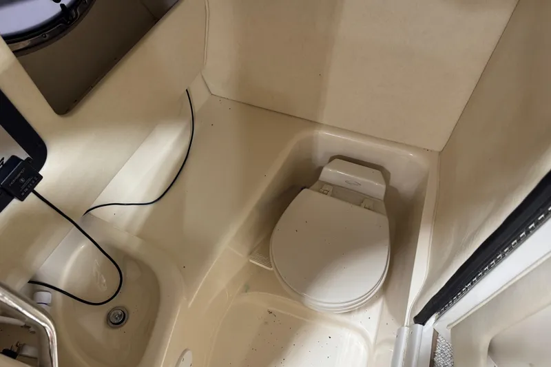 Slide: The Image of 2005 Sea Ray 290 SLX boat interior with compact bathroom and toilet. - 10
