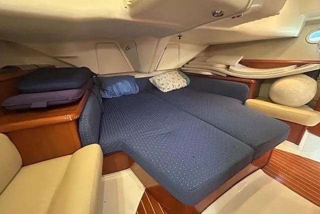 Slide: The Image of 2005 Jeanneau Deck Salon 43 interior with cozy blue bedding and wooden accents. - 13
