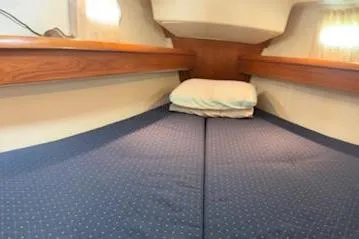 Slide: The Image of 2005 Jeanneau Deck Salon 43 interior cabin with cozy bedding and wooden accents. - 19