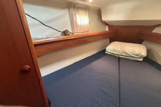 Slide: The Image of Cozy cabin interior of 2005 Jeanneau Deck Salon 43 with blue bedding and wooden accents. - 20