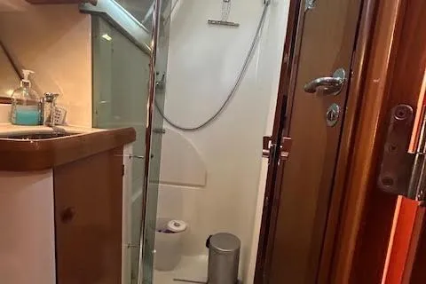 Slide: The Image of 2005 Jeanneau Deck Salon 43 bathroom with shower, sink, and wooden cabinetry. - 26