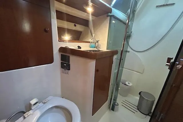 Slide: The Image of Bathroom interior of 2005 Jeanneau Deck Salon 43 yacht, featuring shower and wooden cabinetry. - 27