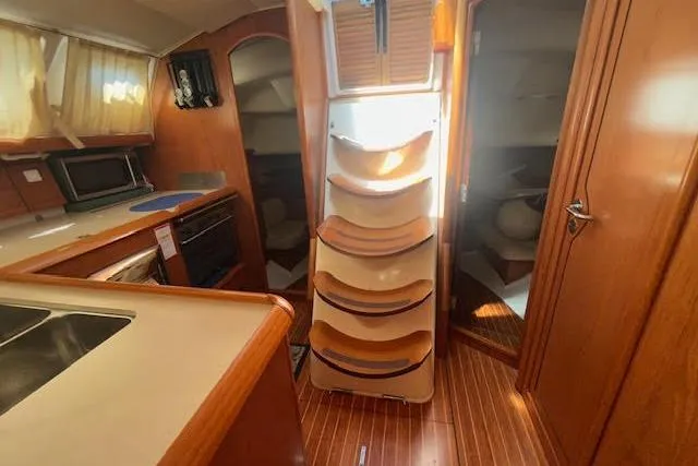 Slide: The Image of Interior of 2005 Jeanneau Deck Salon 43 yacht with wooden cabinetry and modern kitchen. - 30