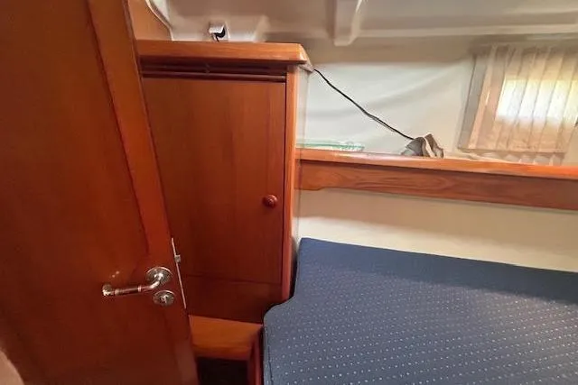 Slide: The Image of Interior cabin of 2005 Jeanneau Deck Salon 43 with wooden cabinetry and blue bedding. - 32