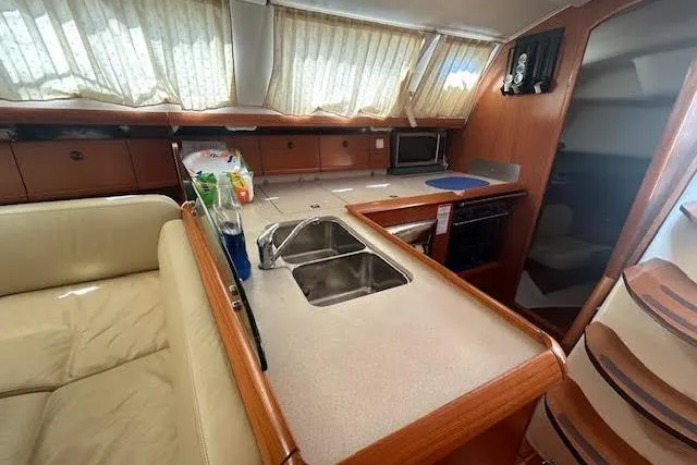 Slide: The Image of Interior of 2005 Jeanneau Deck Salon 43 yacht with kitchen and seating area. - 33