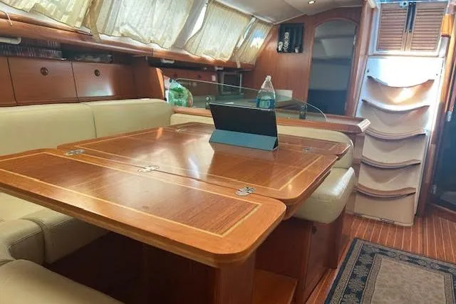 Slide: The Image of Interior of 2005 Jeanneau Deck Salon 43 with elegant wood table and seating. - 42