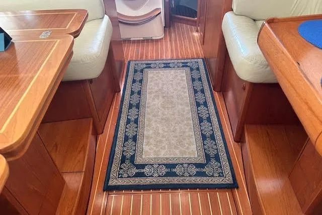 Slide: The Image of Interior of 2005 Jeanneau Deck Salon 43 with elegant wood finish and decorative rug. - 46