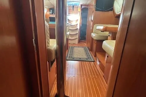 Slide: The Image of Interior of 2005 Jeanneau Deck Salon 43, featuring wood flooring and seating area. - 48