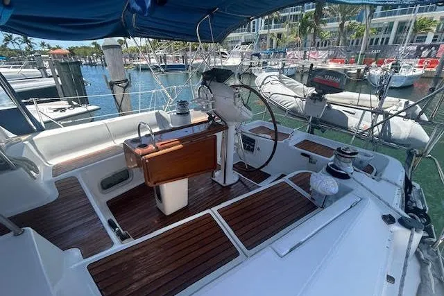 Slide: The Image of 2005 Jeanneau Deck Salon 43 sailboat cockpit with wooden accents, docked at marina. - 5