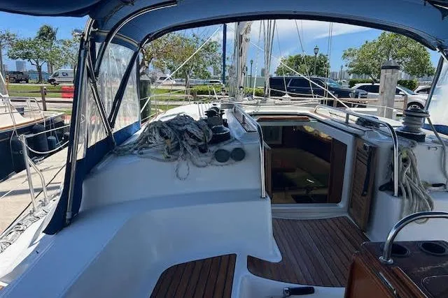 Slide: The Image of 2005 Jeanneau Deck Salon 43 sailboat cockpit with blue canopy and marina view. - 6