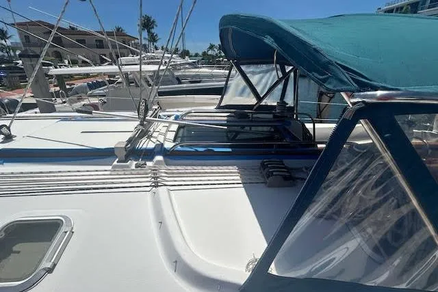 Slide: The Image of 2005 Jeanneau Deck Salon 43 sailboat with blue canopy, docked in marina. - 7