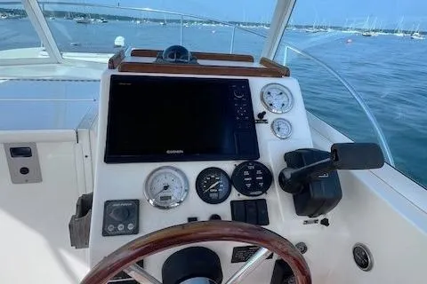 Slide: The Image of 2004 Hunt Yachts Surfhunter 25 dashboard with gauges and steering wheel, overlooking a marina. - 10