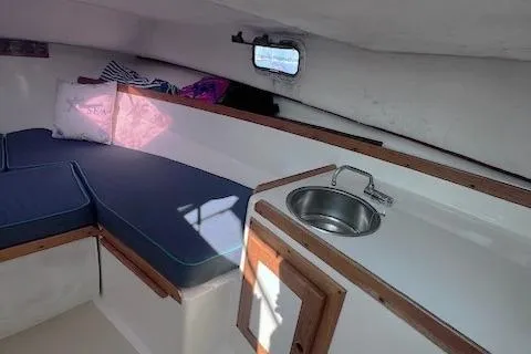 Slide: The Image of 2004 Hunt Yachts Surfhunter 25 cabin interior with seating and small sink. - 20