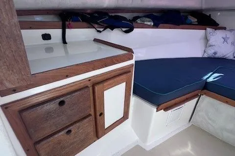 Slide: The Image of 2004 Hunt Yachts Surfhunter 25 cabin interior with wooden cabinetry and cushioned seating. - 21