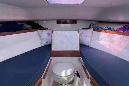 Slide: The Image of 2004 Hunt Yachts Surfhunter 25 cabin interior with seating and marine toilet. - 24