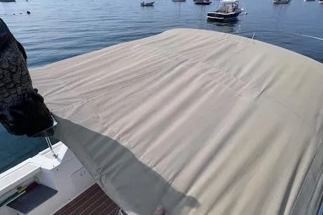 Slide: The Image of 2004 Hunt Yachts Surfhunter 25 with beige cover on calm water. - 25