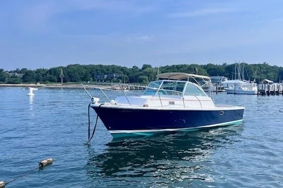 Slide: The Image of 2004 Hunt Yachts Surfhunter 25 boat anchored in a serene harbor setting. - 3