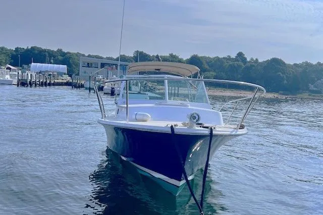 Slide: The Image of 2004 Hunt Yachts Surfhunter 25 in calm waters near a marina. - 4