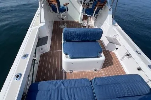 Slide: The Image of 2004 Hunt Yachts Surfhunter 25 interior with blue seating and wooden deck. - 6
