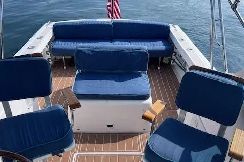 Slide: The Image of 2004 Hunt Yachts Surfhunter 25 with blue seating and wooden deck, docked on water. - 7