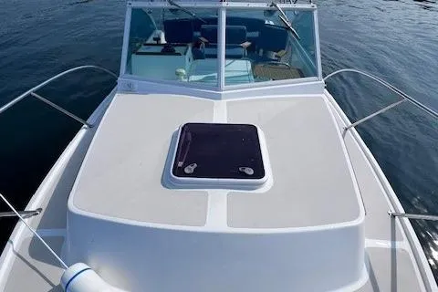 Slide: The Image of 2004 Hunt Yachts Surfhunter 25 boat on calm water, featuring a sleek deck design. - 13